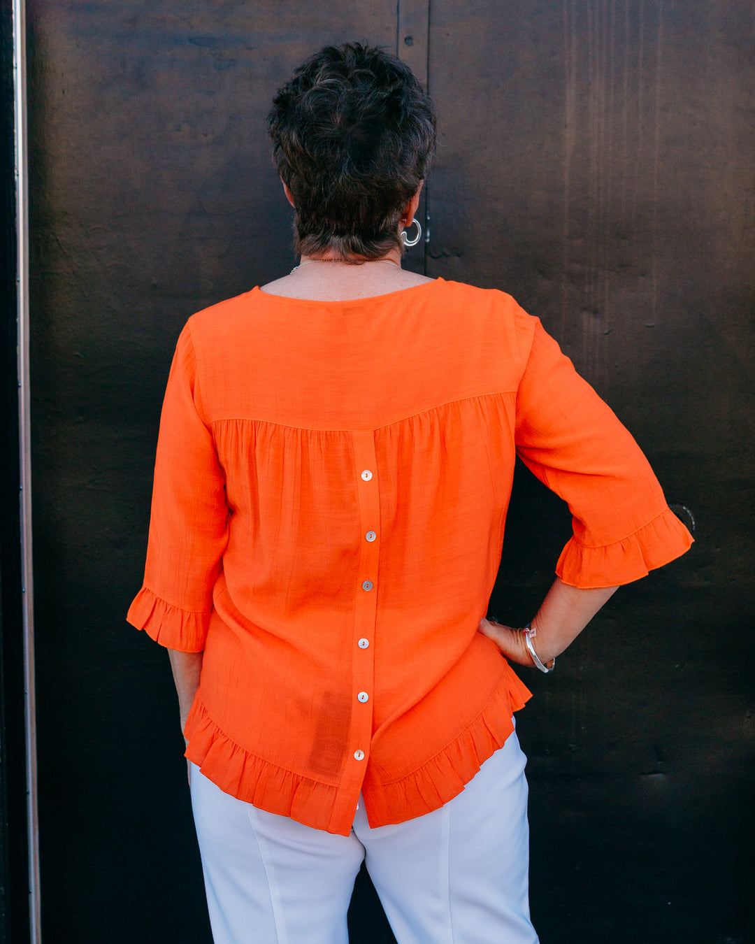 Multiples: Elbow Sleeve Scoop Neck Ruffle Hi-Lo Button Bk Top in International Orange (M26511TM) - The Vogue Boutique