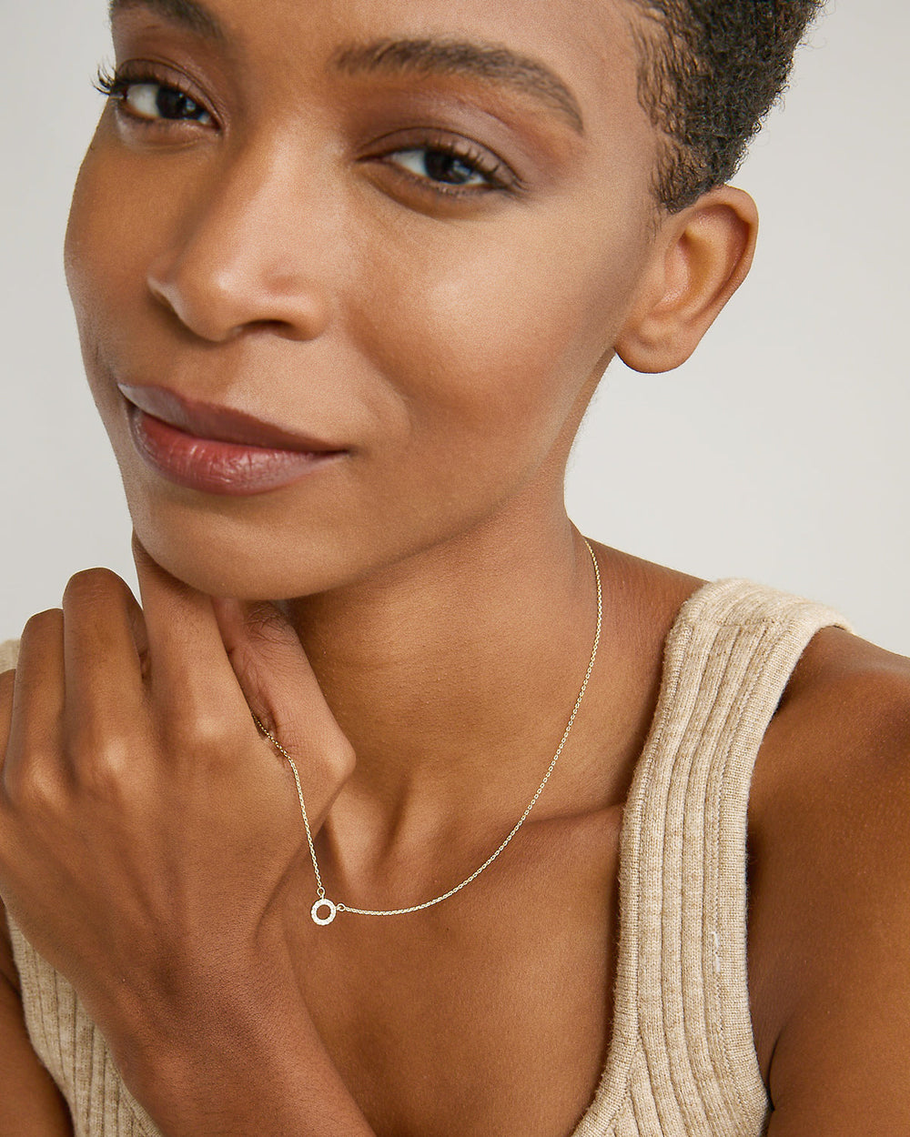 Woman wearing delicate silver chain necklace with small circular pendant