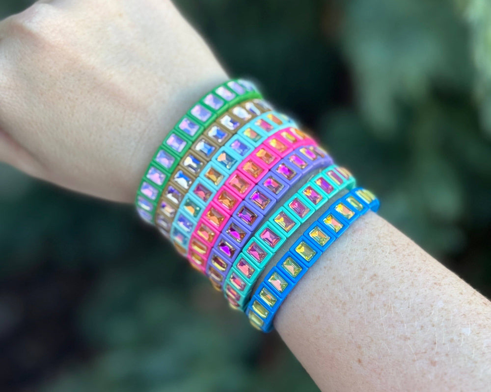 Colorful enamel stretch bracelets with small square gems in rainbow colors on wrist