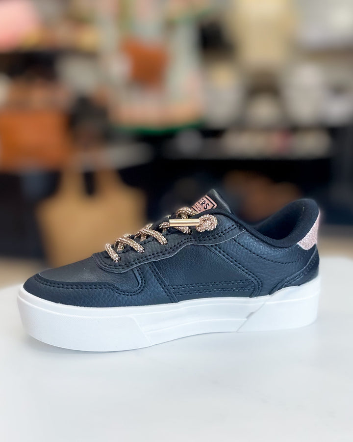 Black sneaker with white sole on a blurred background