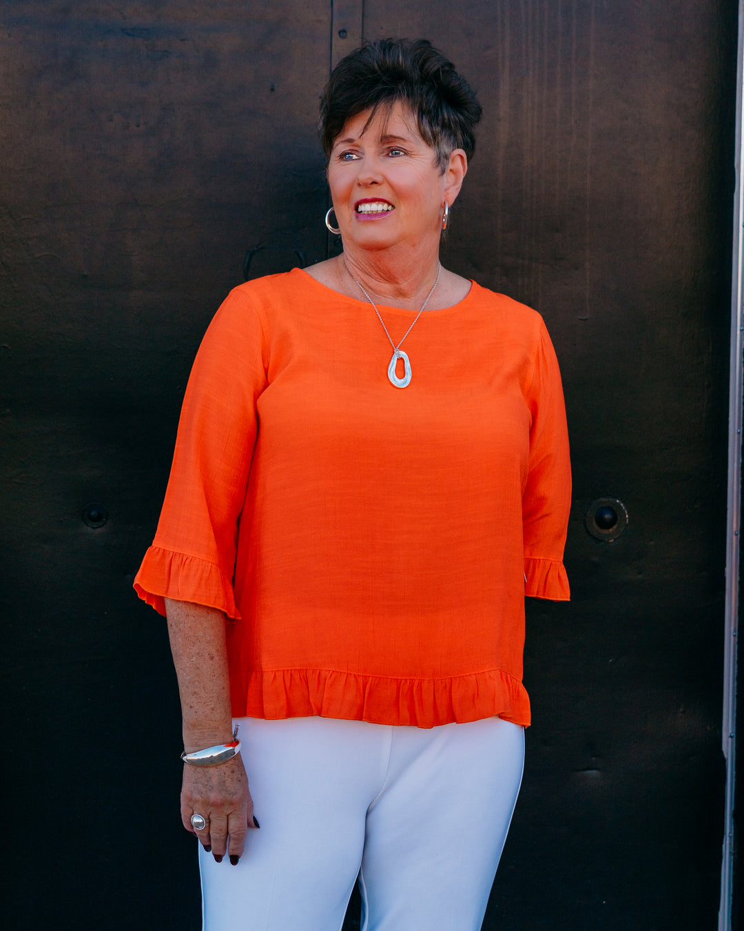 Multiples: Elbow Sleeve Scoop Neck Ruffle Hi-Lo Button Bk Top in International Orange (M26511TM) - The Vogue Boutique