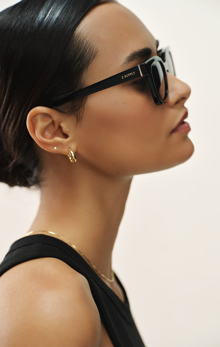 Woman wearing Z Supply High Tide Polished Black sunglasses with grey polarized lenses in profile view