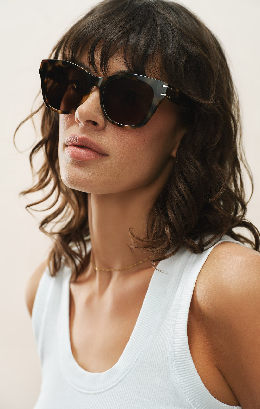 Woman wearing Z Supply Front Row Brown Tortoise sunglasses with white tank top