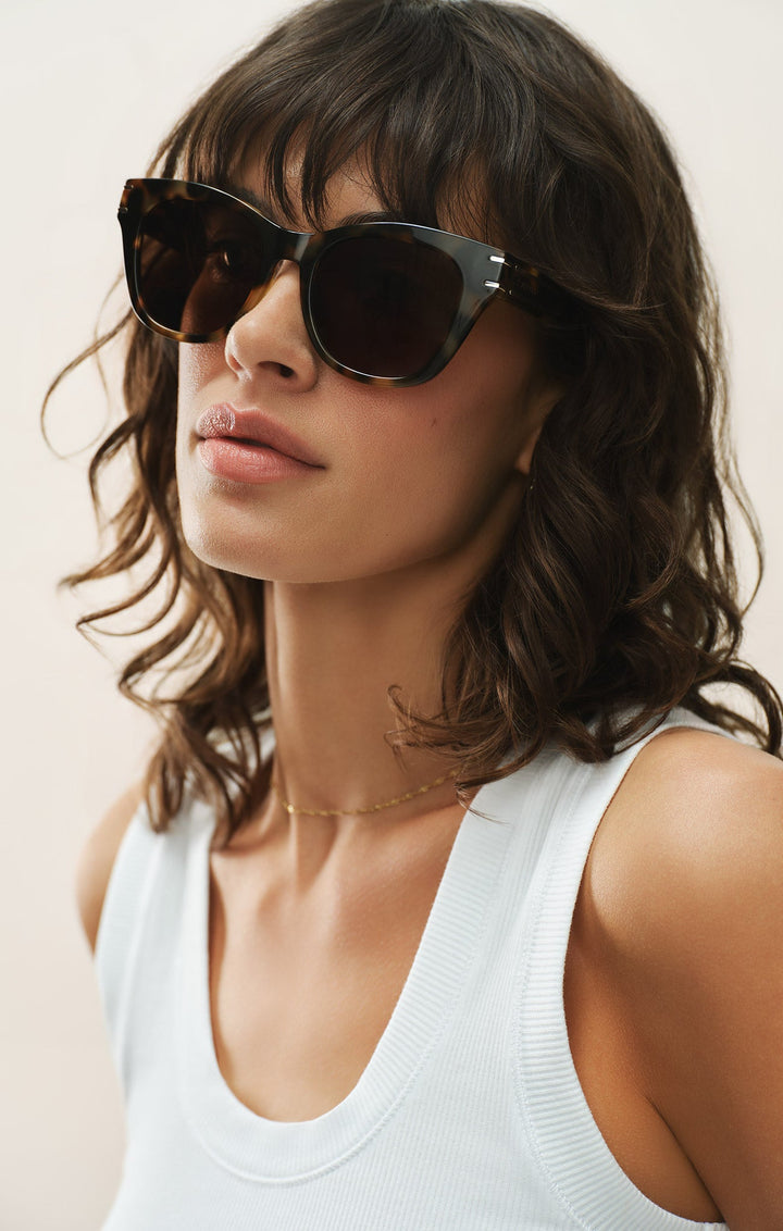 Woman wearing Z Supply Front Row Brown Tortoise sunglasses with white tank top