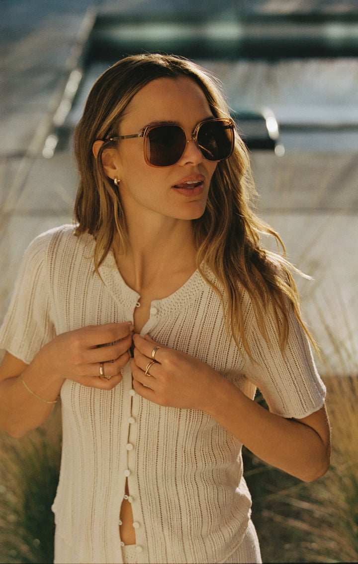 Woman wearing brown tortoise oversized square sunglasses with gradient lenses outdoors