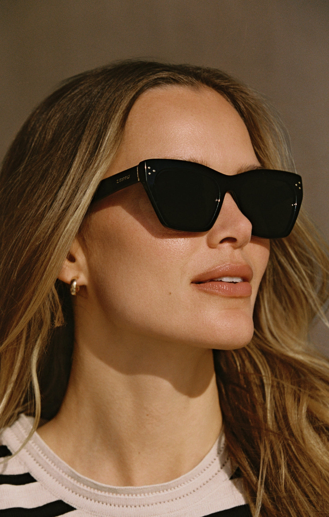 Woman wearing Z Supply Park Ave Polished Black sunglasses with dark polarized lenses