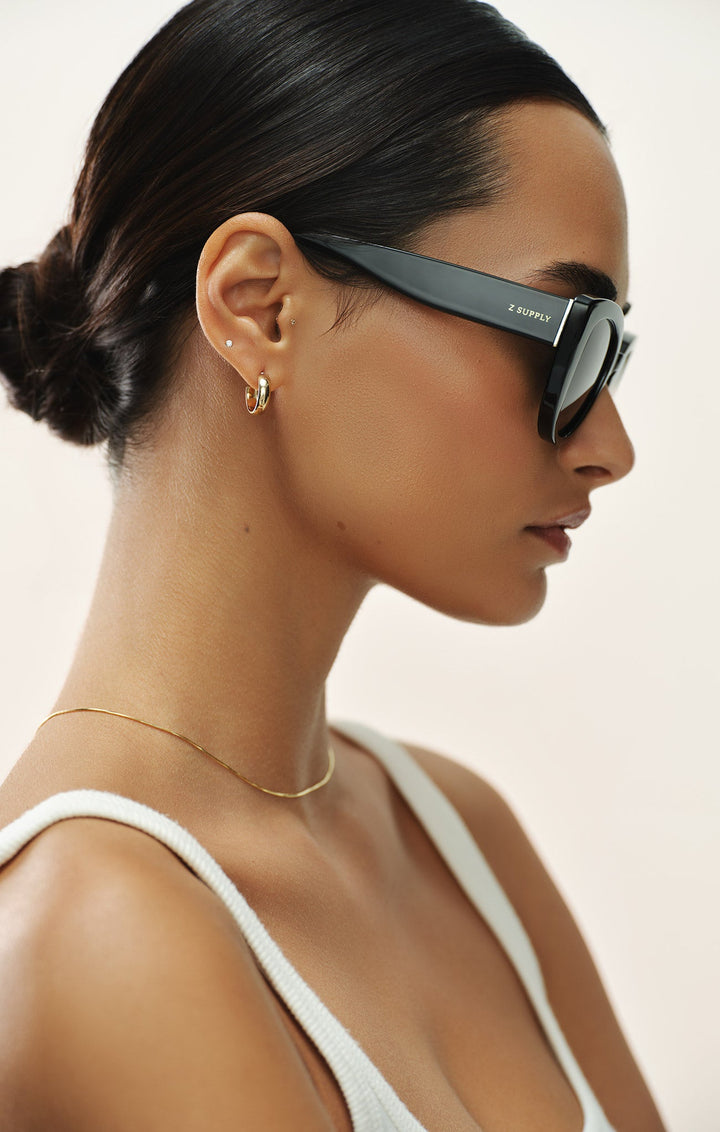 Woman wearing Z Supply Golden Hour Polished Black sunglasses with grey polarized lenses in profile view