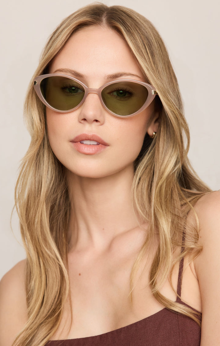 Woman wearing Z Supply Palermo cat-eye sunglasses with blush pink frames and olive green lenses