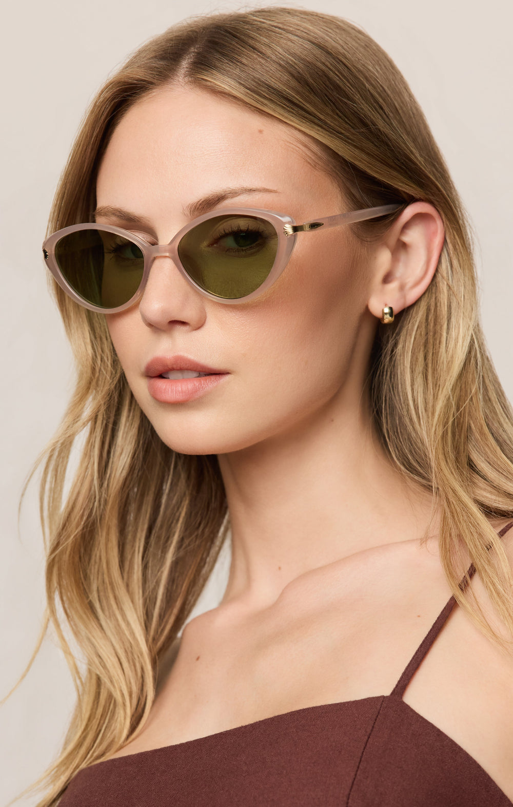 Woman wearing Z Supply Palermo cat-eye sunglasses in frosted blush with green lenses
