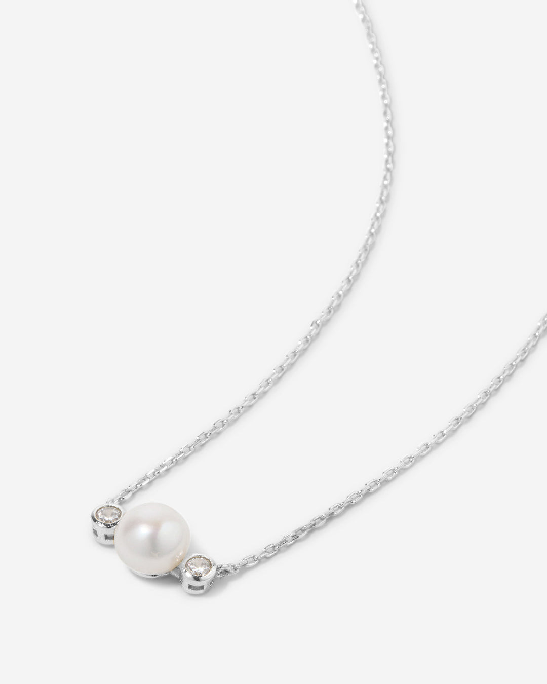 Delicate necklace with white pearl and crystal accents on silver chain