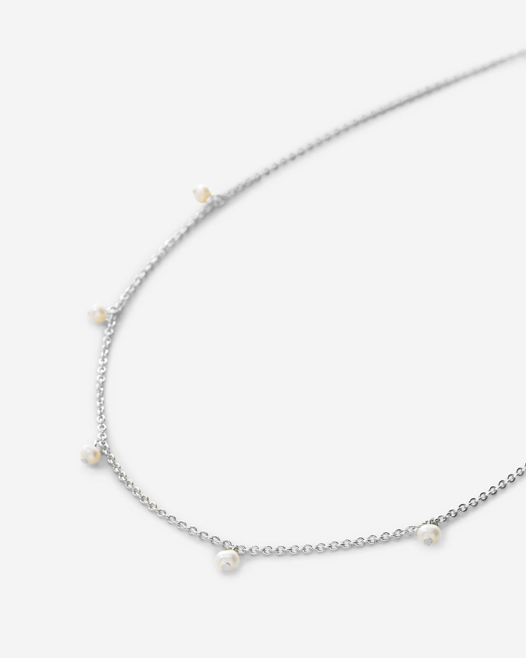 Silver chain choker necklace with small pearl-like dangles on clean background
