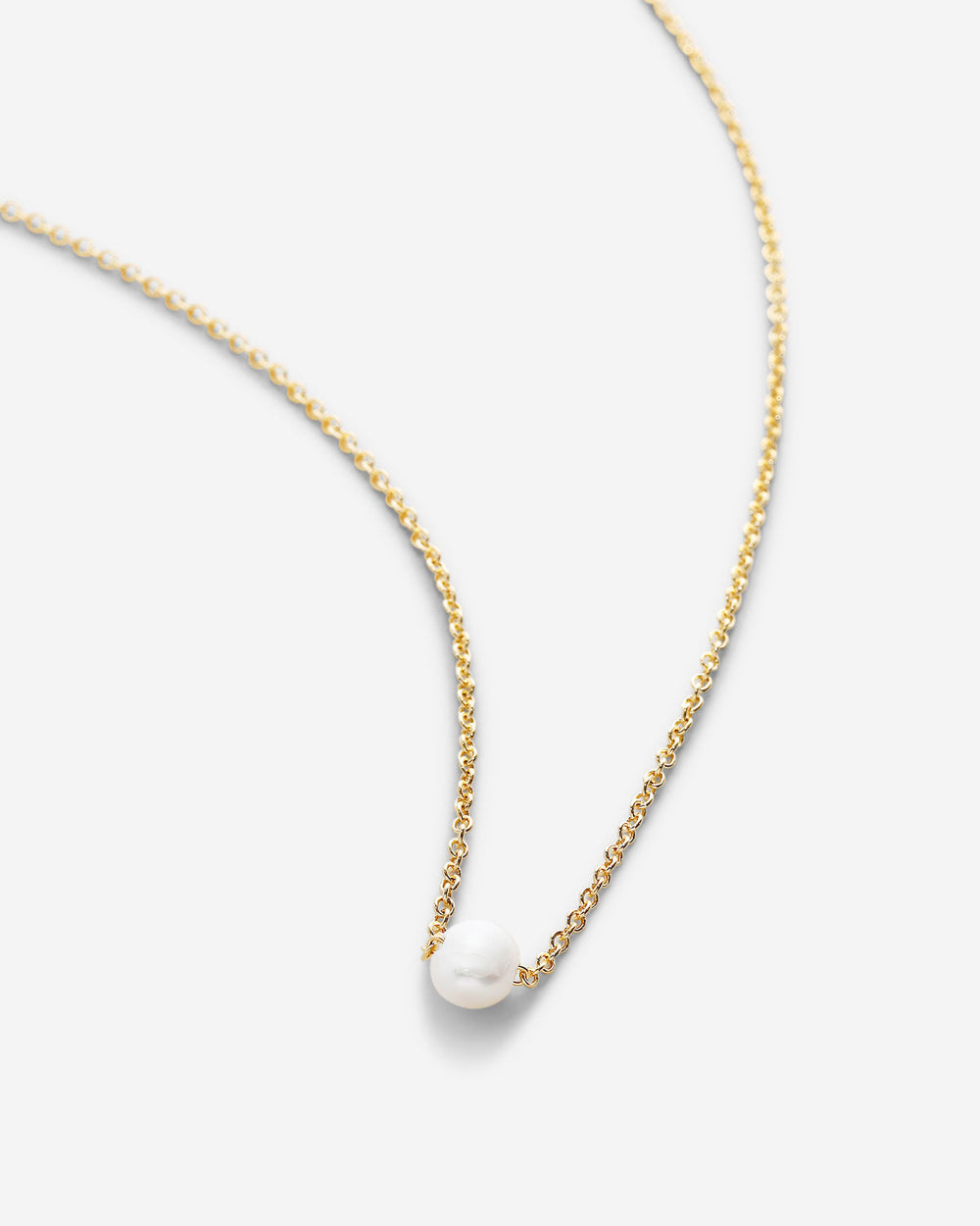 Delicate 14k gold chain necklace with single white pearl pendant on clean background