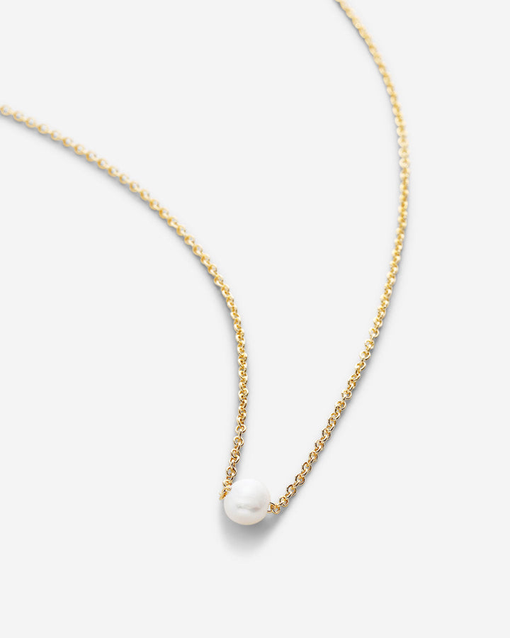 Delicate 14k gold chain necklace with single white pearl pendant on clean background