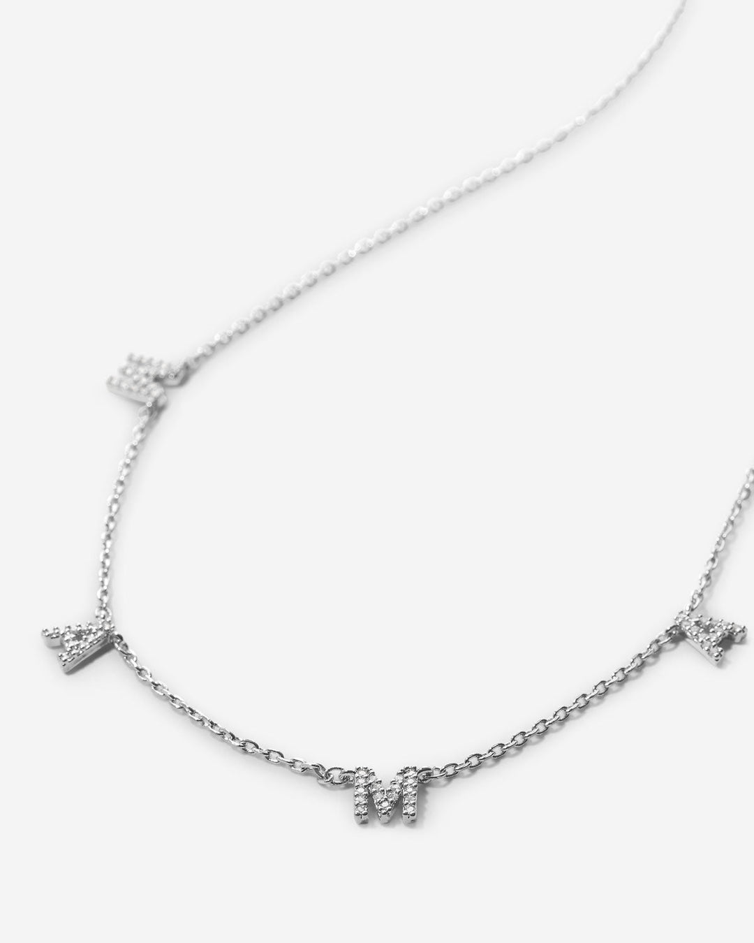 Silver chain necklace with crystal-studded MAMA letter charms on white background