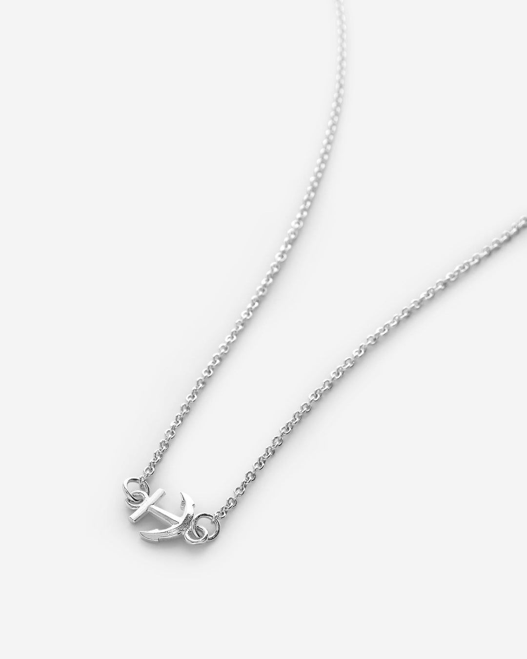 Silver anchor necklace with delicate chain on clean white background