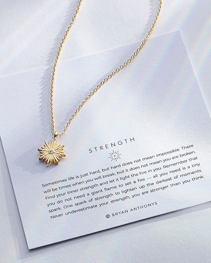 Bryan Anthonys Strength necklace with gold sunburst pendant and inspirational card