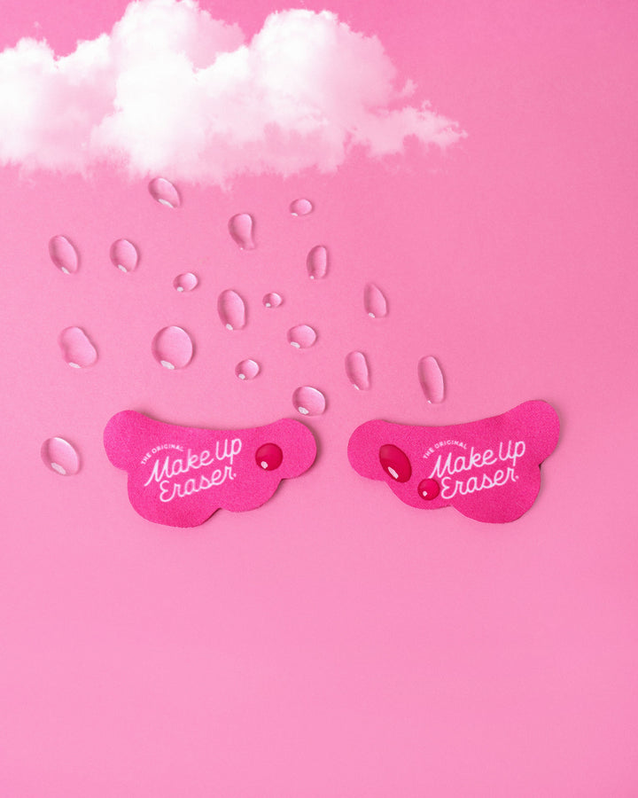 Pink cloud-shaped makeup eraser patches with water droplets on pink background
