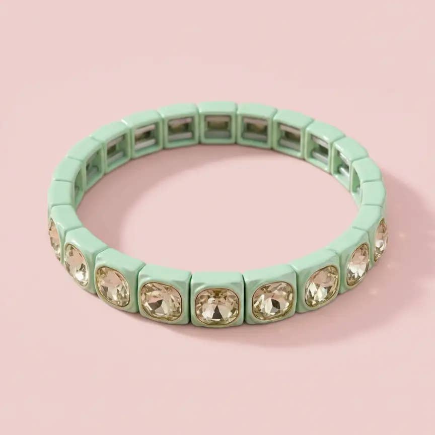 Mint green enamel stretch bracelet with champagne crystal gems on pink background