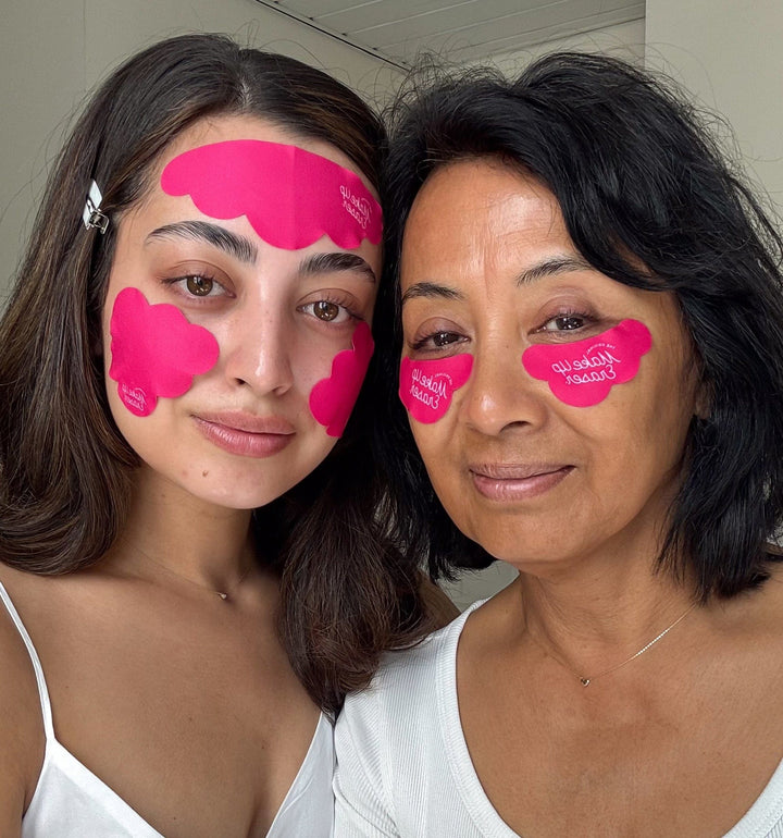Two women wearing bright pink reusable under eye patches on face
